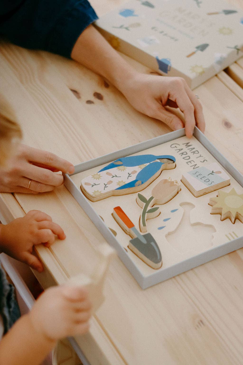 Mary’s Garden puzzle featuring Mary, Flowers, Shovel, Watering can, Seeds, and Sun in a box being played with.