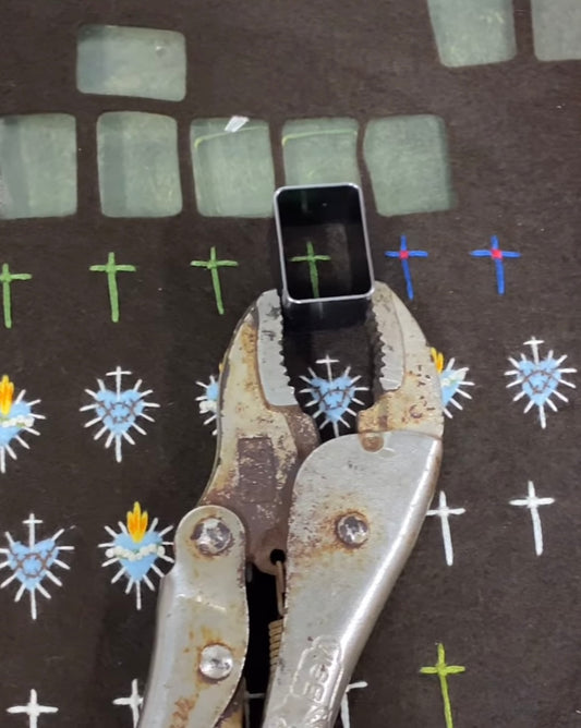 A Tool holding a square cutter around a cross, showing how the Brown Scapulars are constructed.