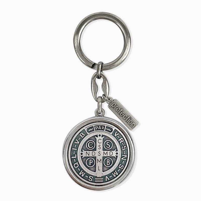 The back side of a silver St. Benedict keychain.