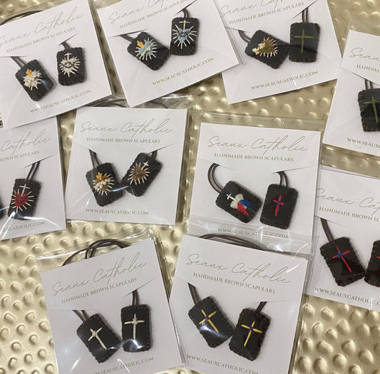 A variety of Brown Scapulars featuring different religious designs offered from Seaux Catholic