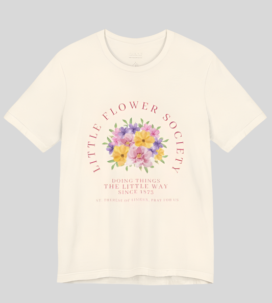An off-white shirt that reads "Little Flower Society" and "Doing things the Little Way since 1873" and "St. Therese of Lisieux, Pray for us." with a floral image in center.