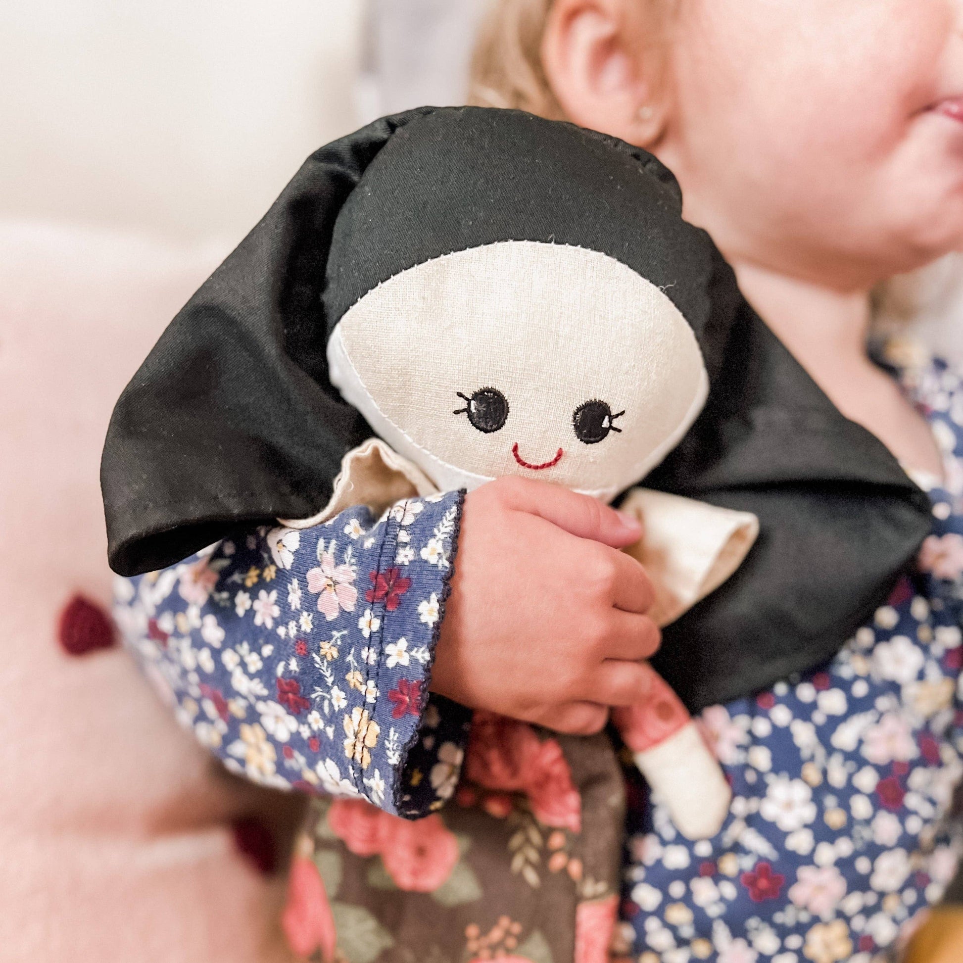 A child holding a St. Therese of Lisieux doll