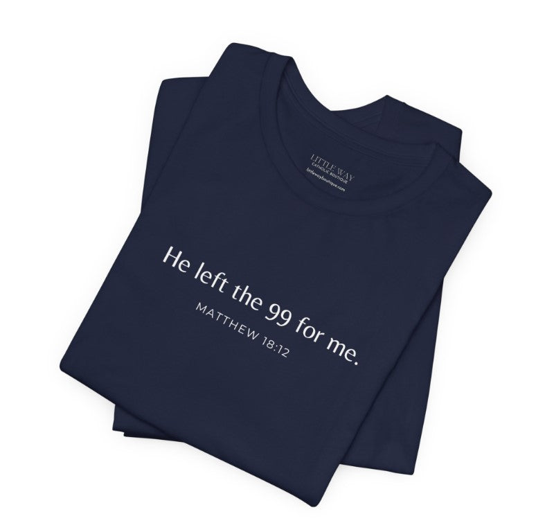 A folded navy blue shirt that reads "He left the 99 for me. Matthew18:12"