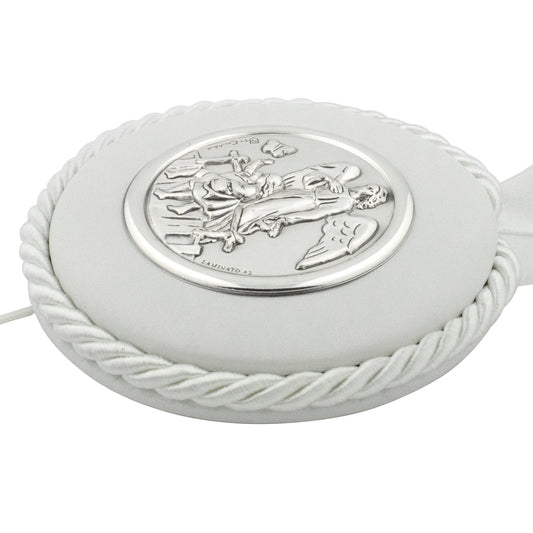Close up of a White Round Baby Crib Medal featuring a guardian angel in silver, hanging on a white ribbon and rope.