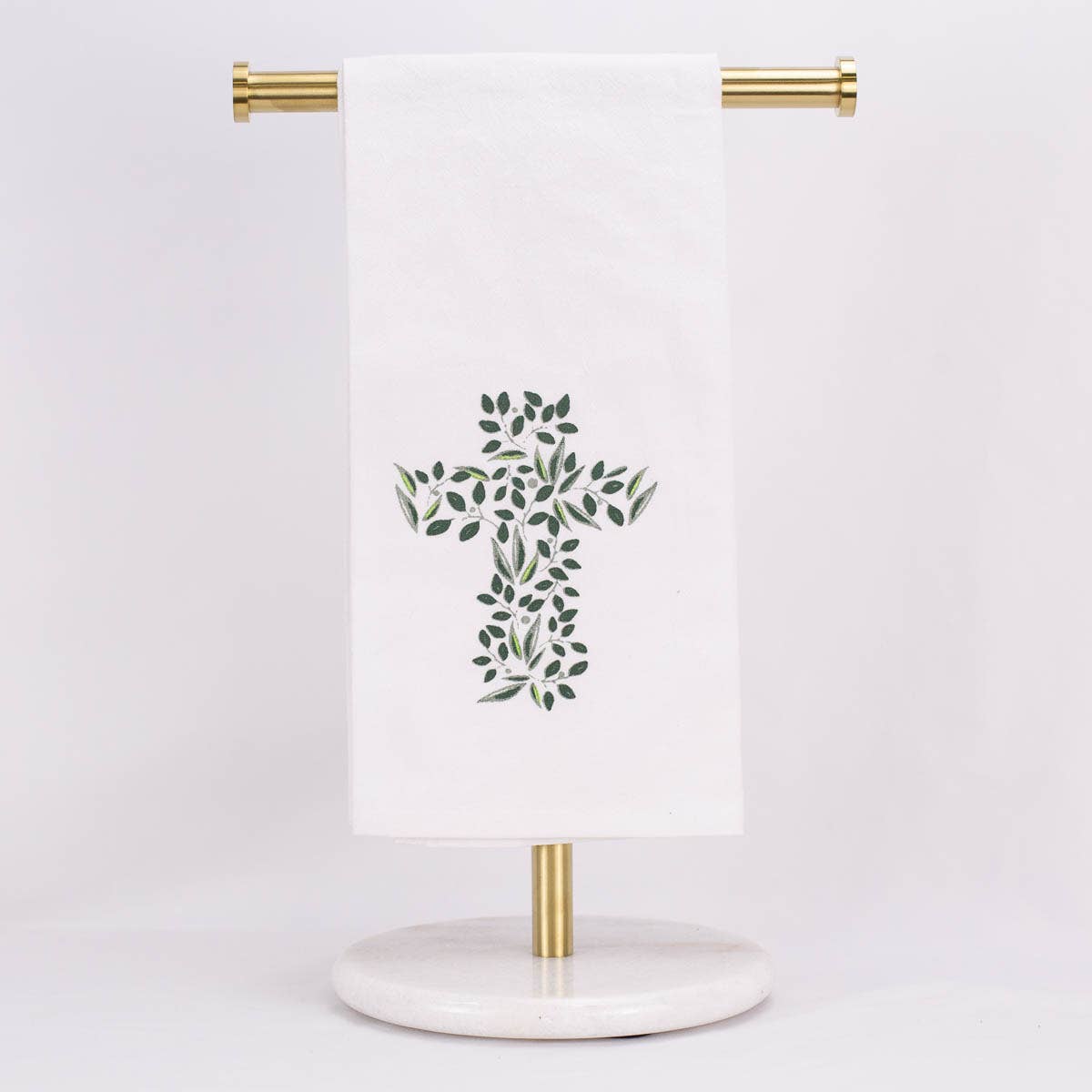 A hand towel featuring a cross out of greenery, displayed on a towel stand.