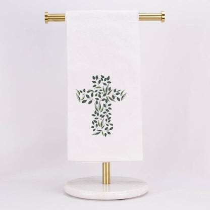 A hand towel featuring a cross out of greenery, displayed on a towel stand.