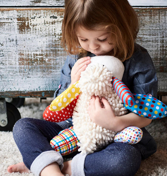Child holding Lamb Doll