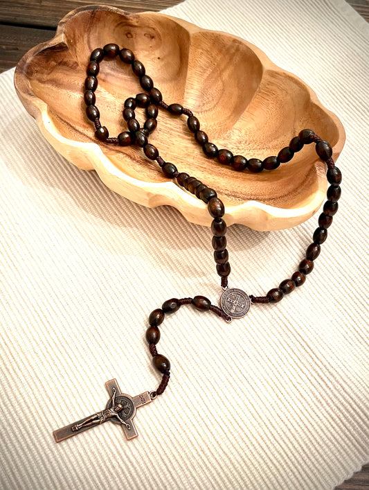 A wooden rosary in a wooden bowl